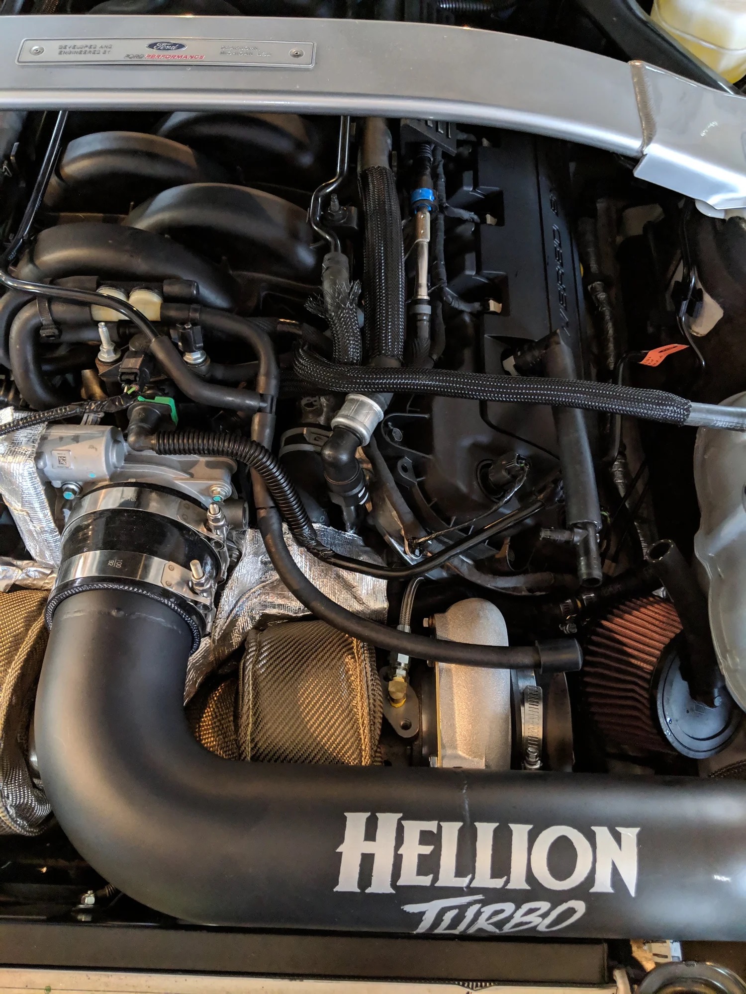 Detailed view of a turbo, wrapped piping, wiring, and the GT350 strut brace